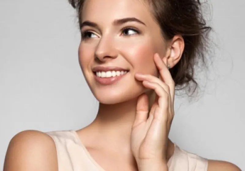 Mulher sorrindo com a mão no rosto